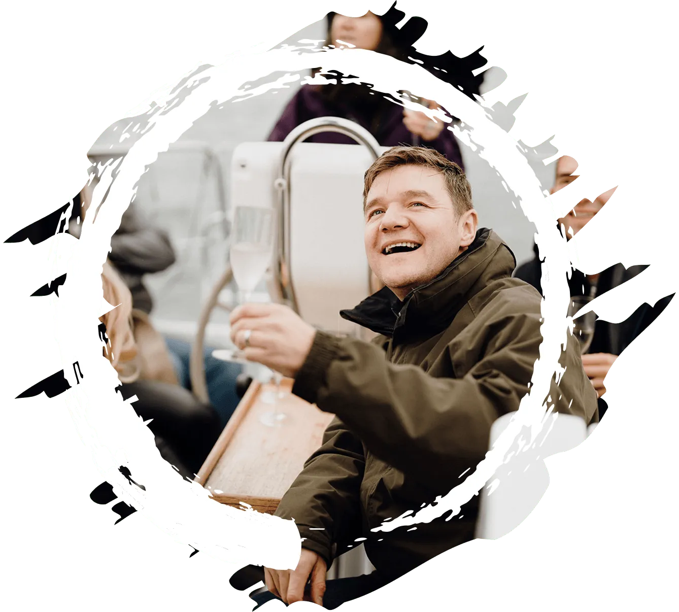 A retreat member on a boar, holding up a class of champagne.