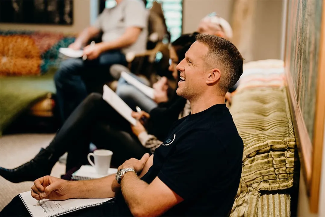 A group of people sitting on a couch in a living room.
