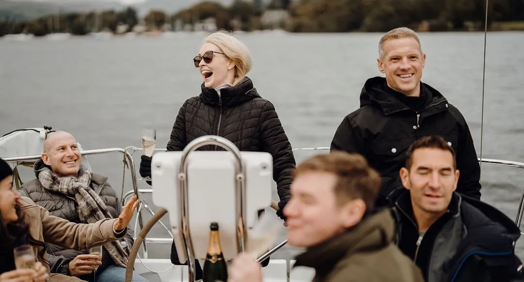 A group of retreat members enjoying sitting on top of a boat drinking champagne.