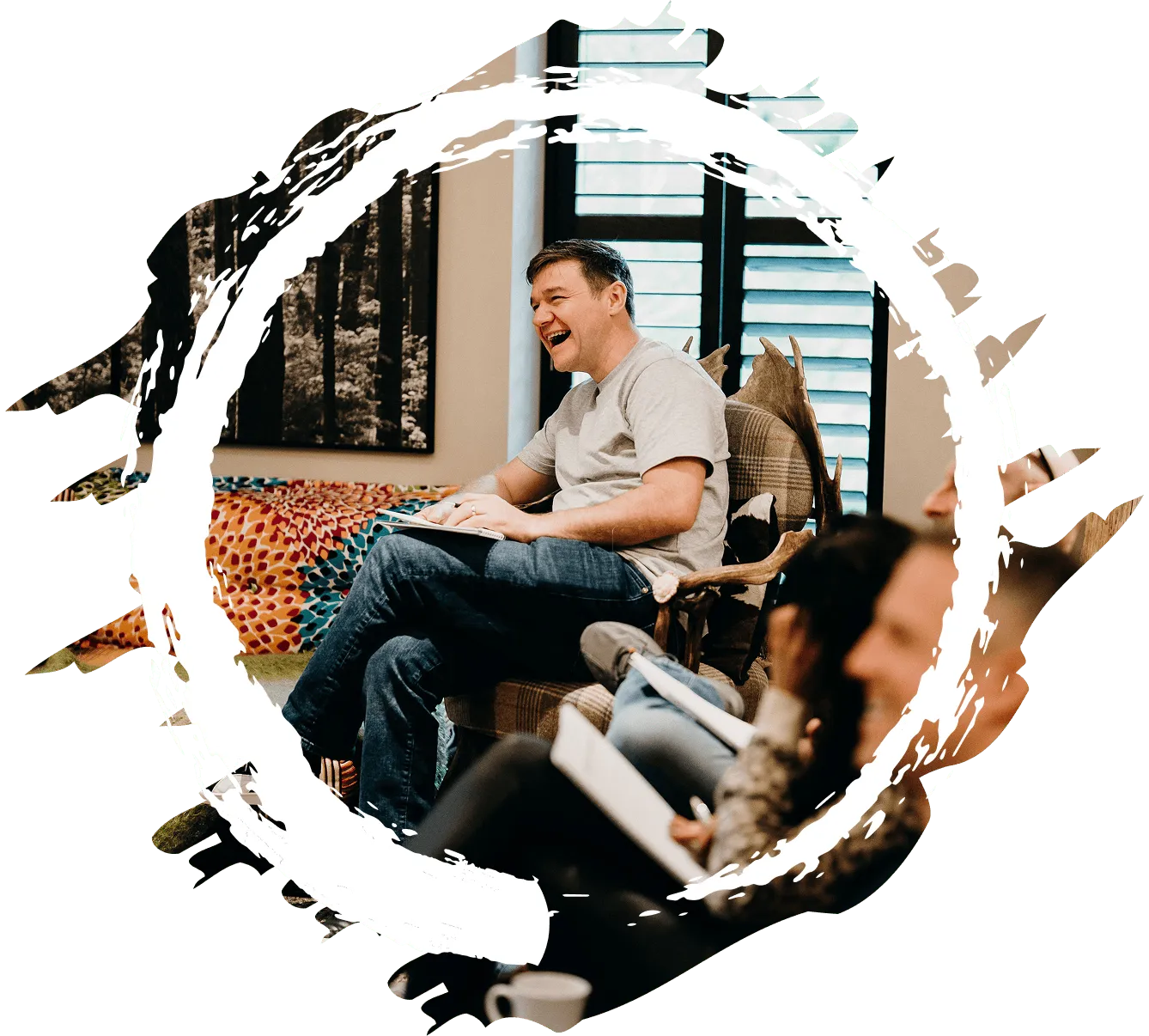 Retreat member sitting in a chair in a living room. Enjoying the discussion with other members.