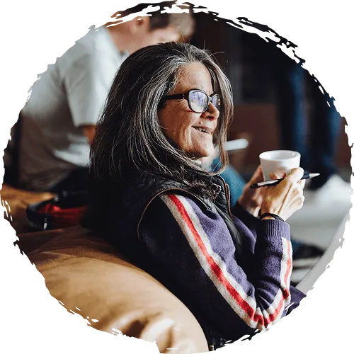 Retreat member sitting on a couch holding a cup of coffee.