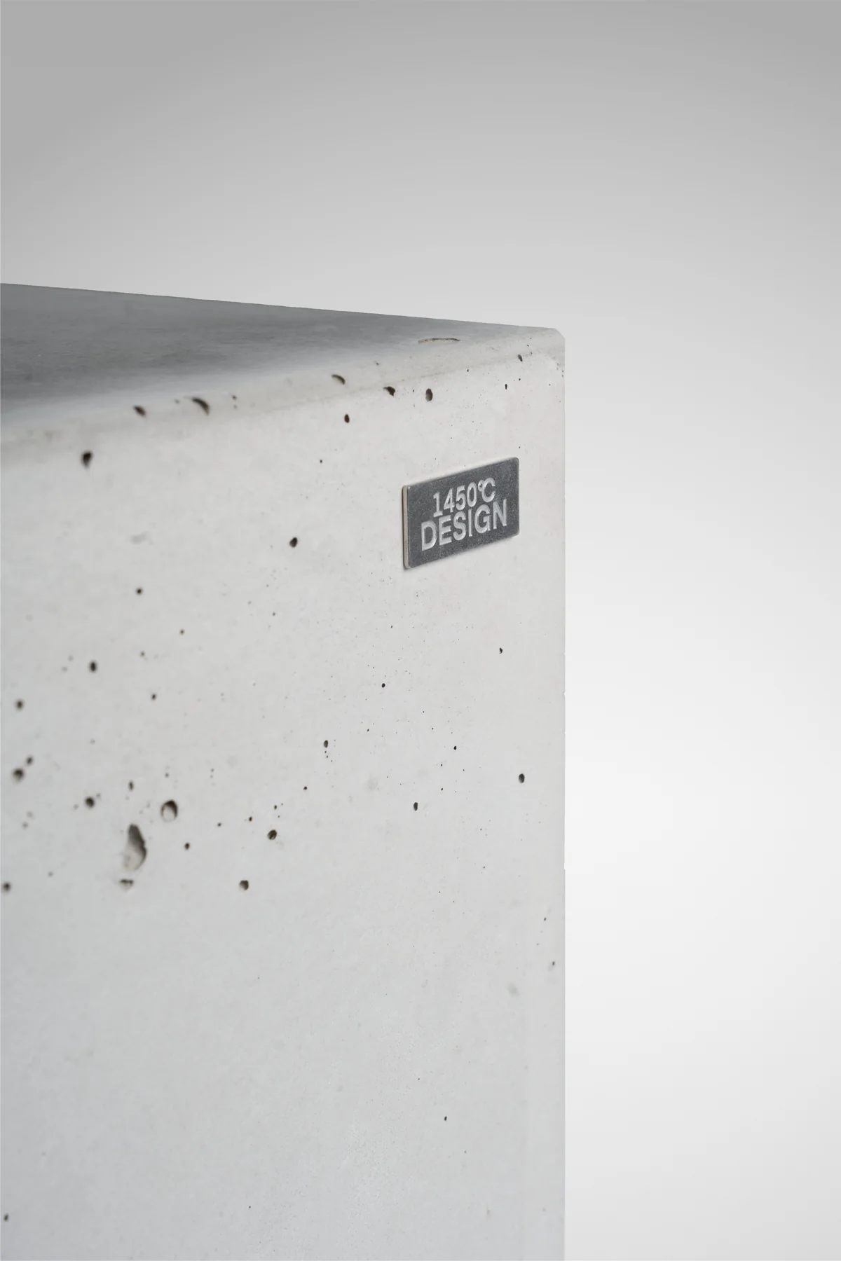 Materialdetail · Betonoberfläche mit 1450°C Design Markenplakette