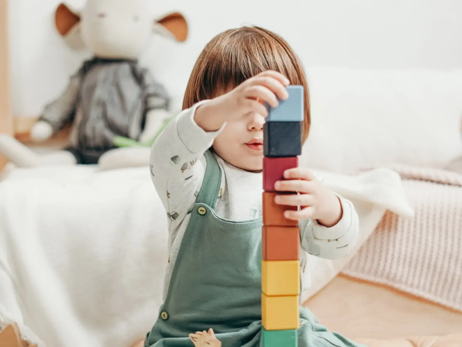 a little girl playing with a wooden block toy
