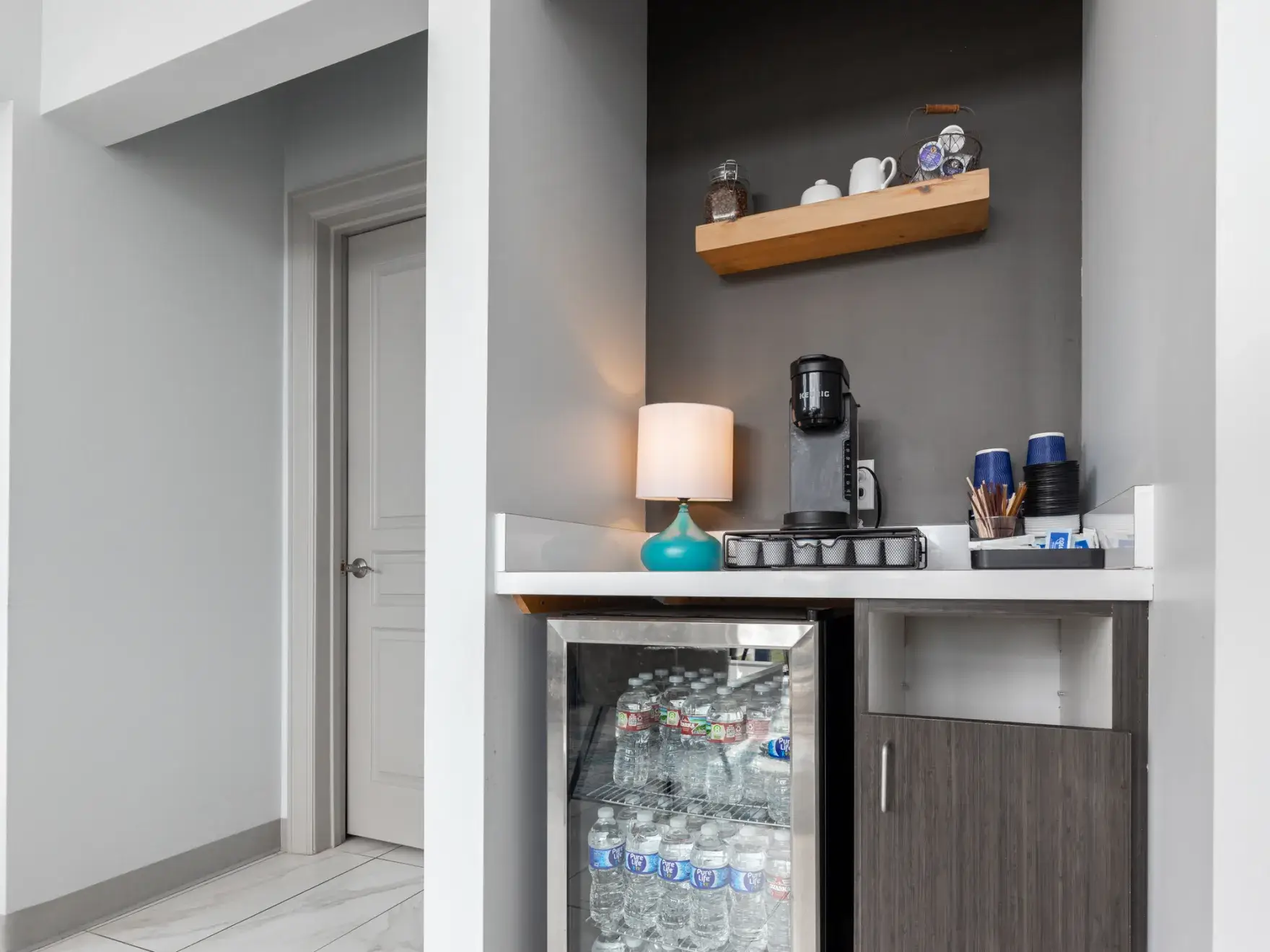 A beverage cooler in the corner of a room.
