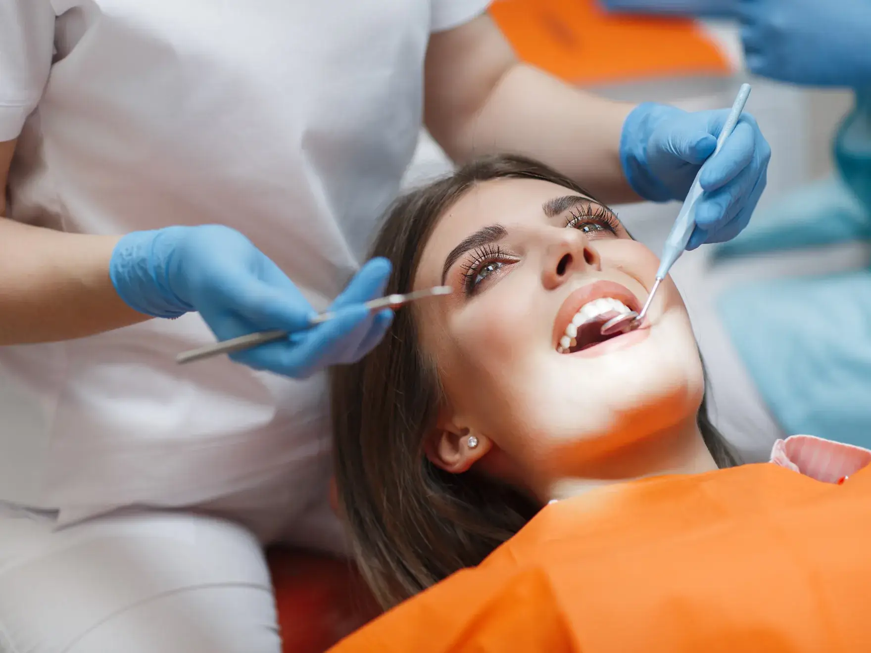A woman getting her teeth checked by a dentist.