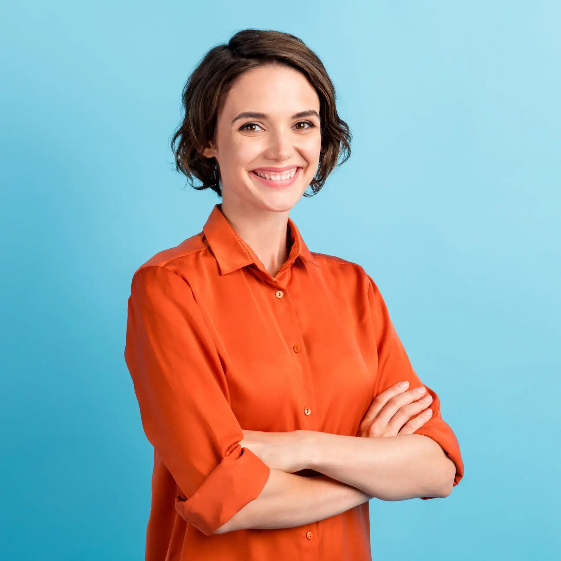 A woman in an orange shirt posing for a picture. 