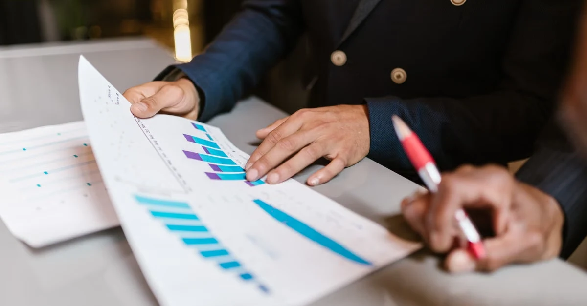 Business professionals analyzing blue bar charts and data visualization for holiday ecommerce strategy planning.