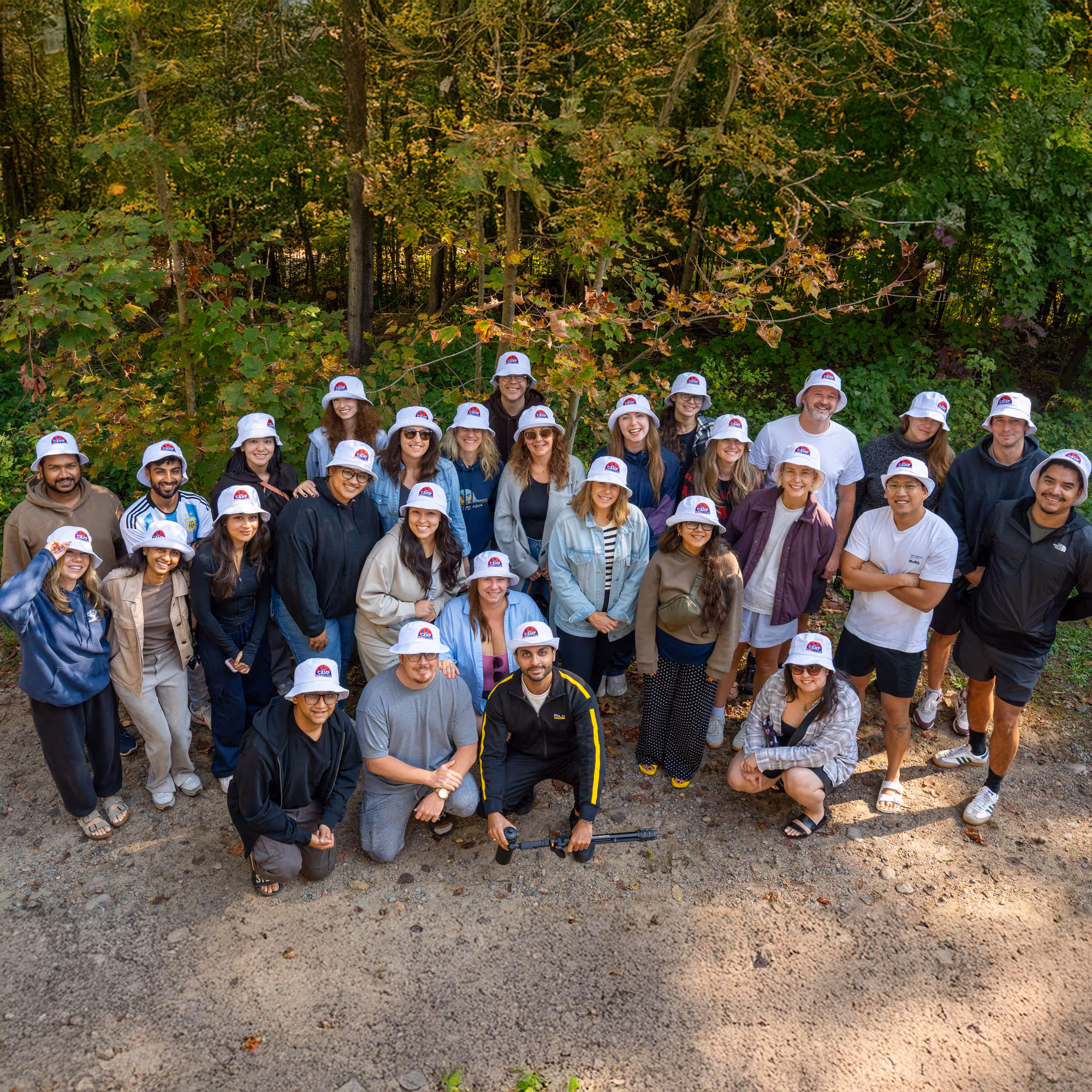 A group of people posing outside in matching bucket hats.