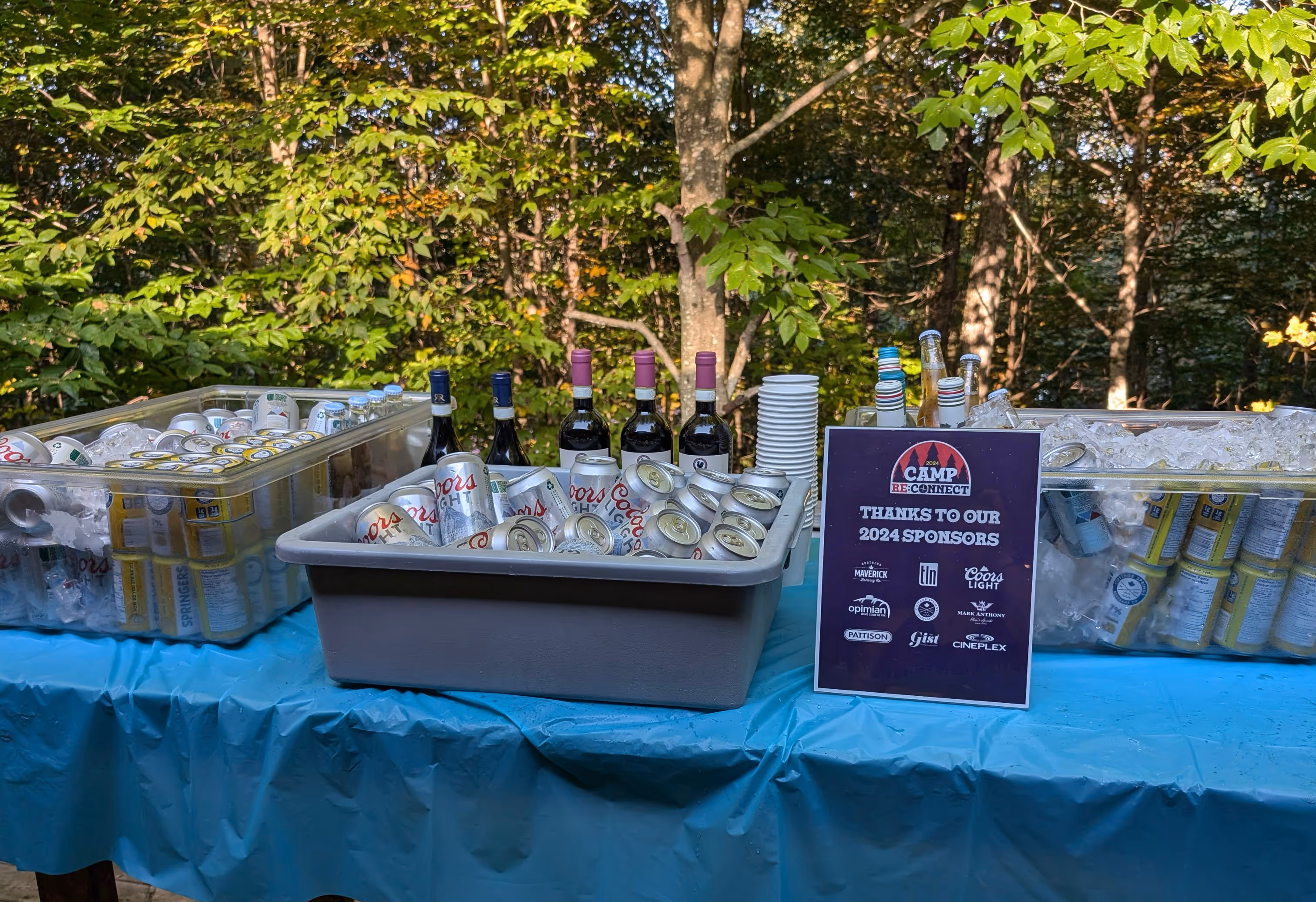 Drinks in coolers on a table.