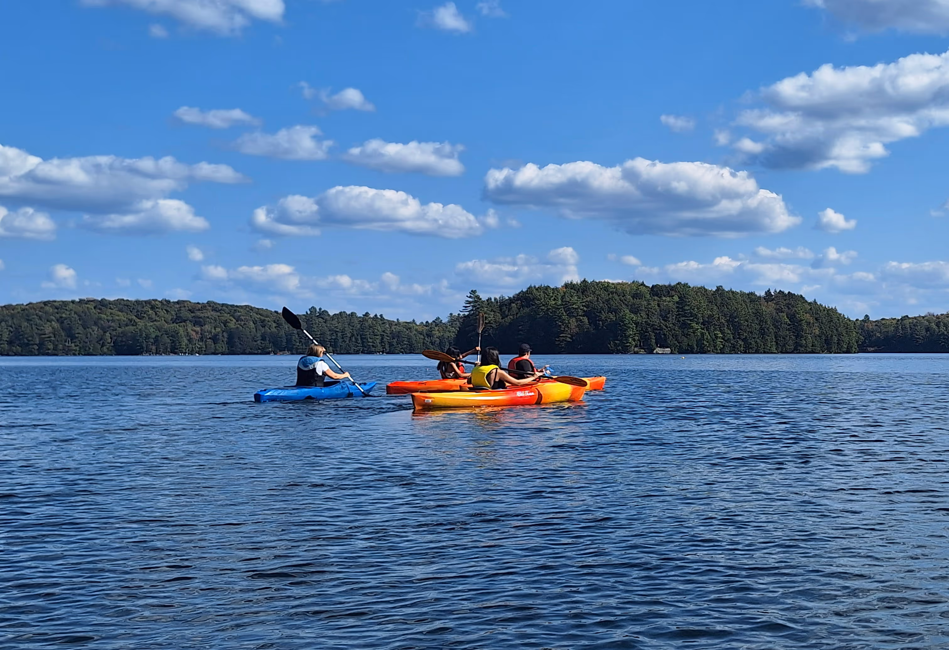 People kayaking on a lake in Muskoka.
