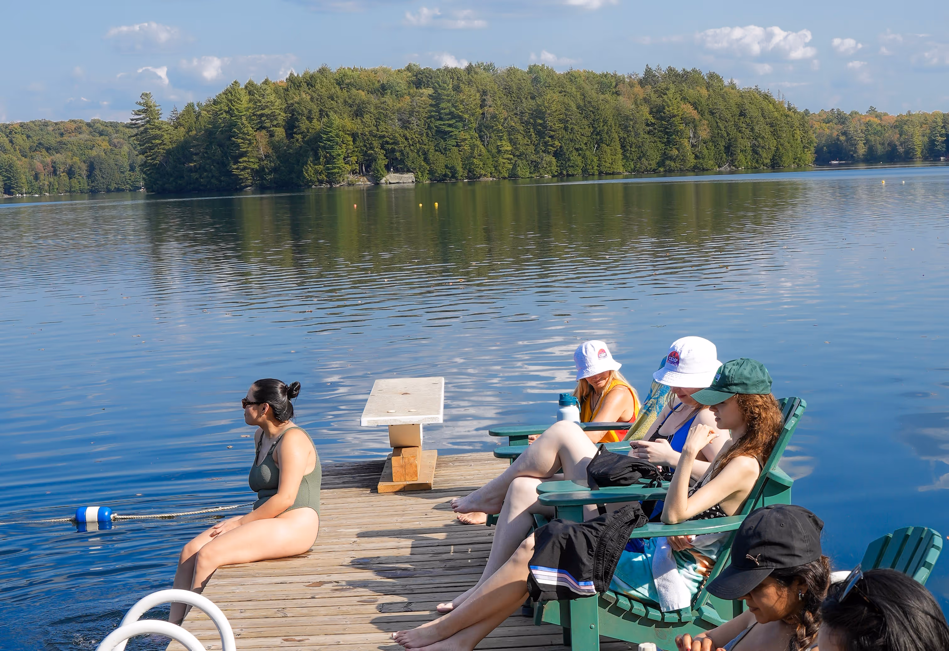 A group of women sitting on a dock.