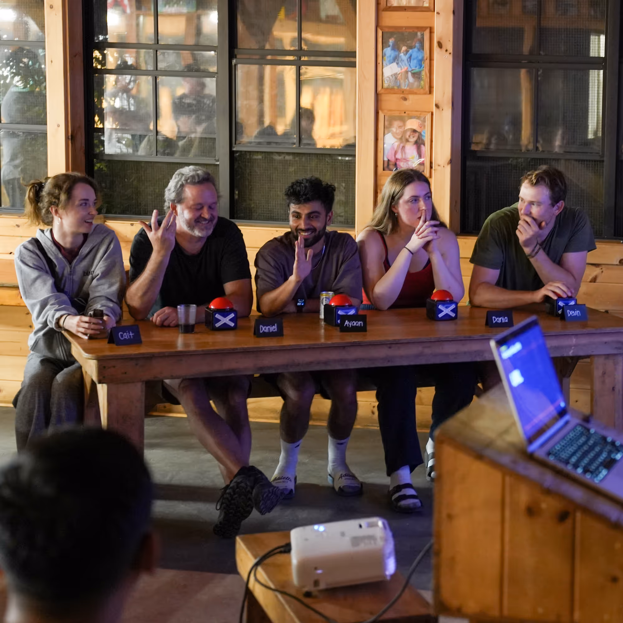 A group of people sitting at a table playing a trivia game.
