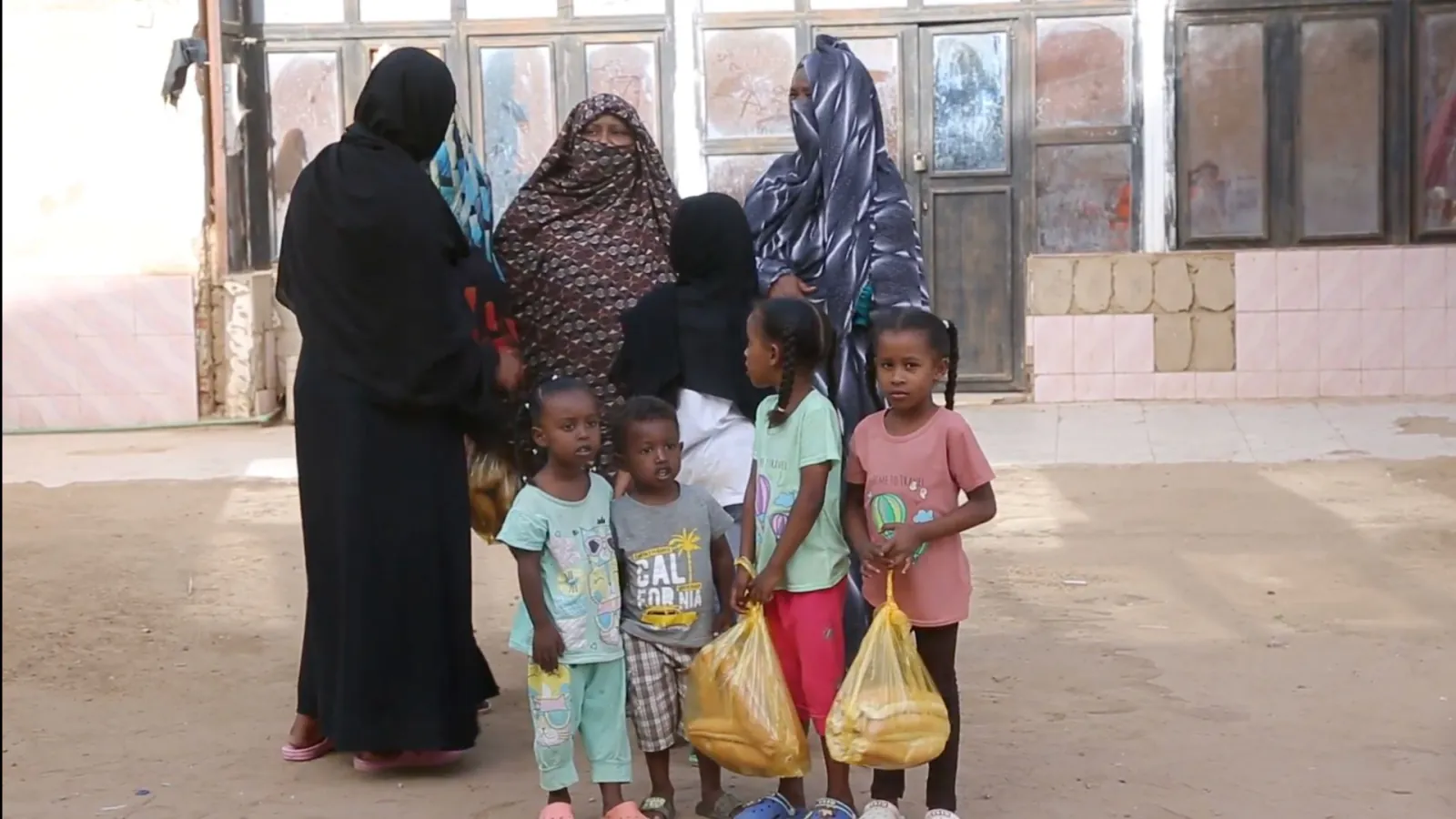 Sudan relief volunteer with Umma Foundation preparing fresh bread for vulnerable displaced families in crisis.
