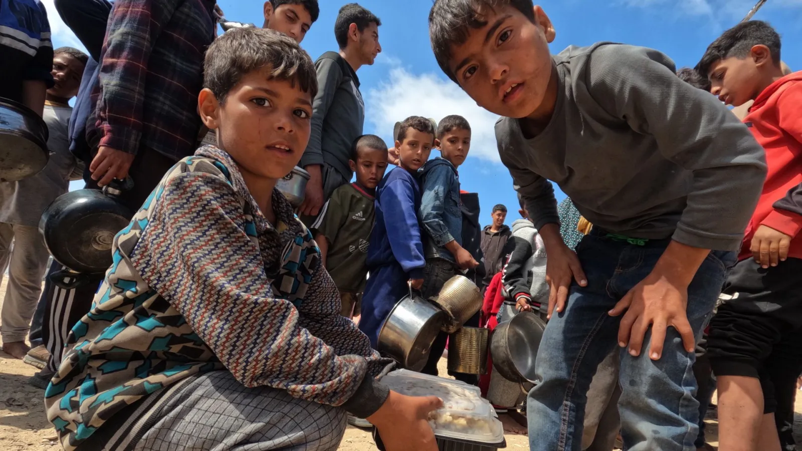 Gaza children receiving food aid in 2025