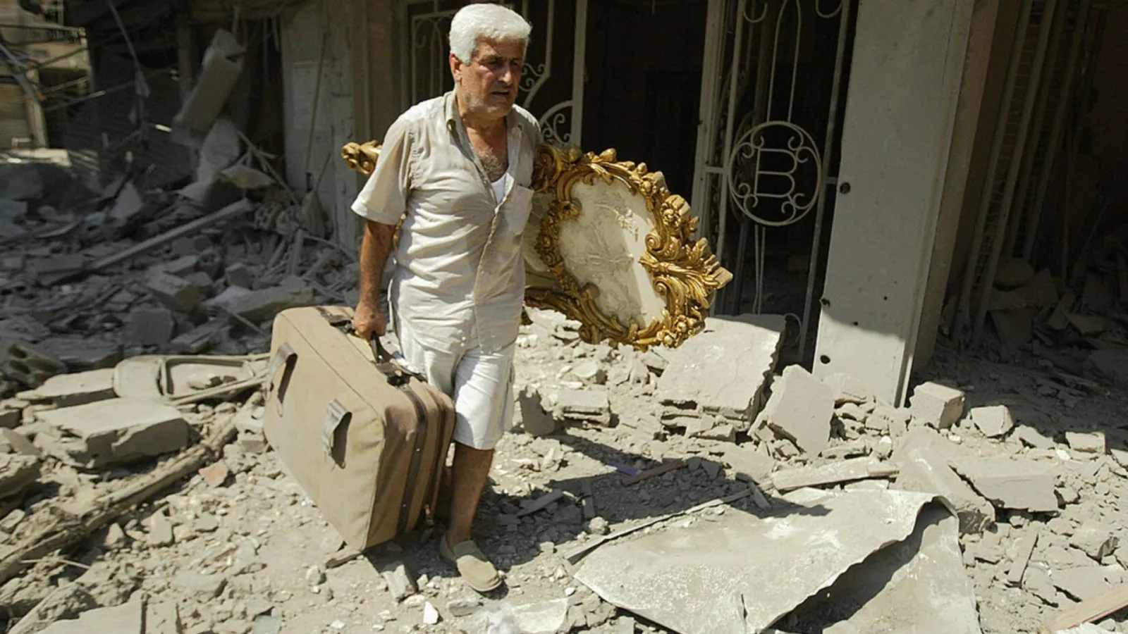 Man with suitcase in Beirut rubble