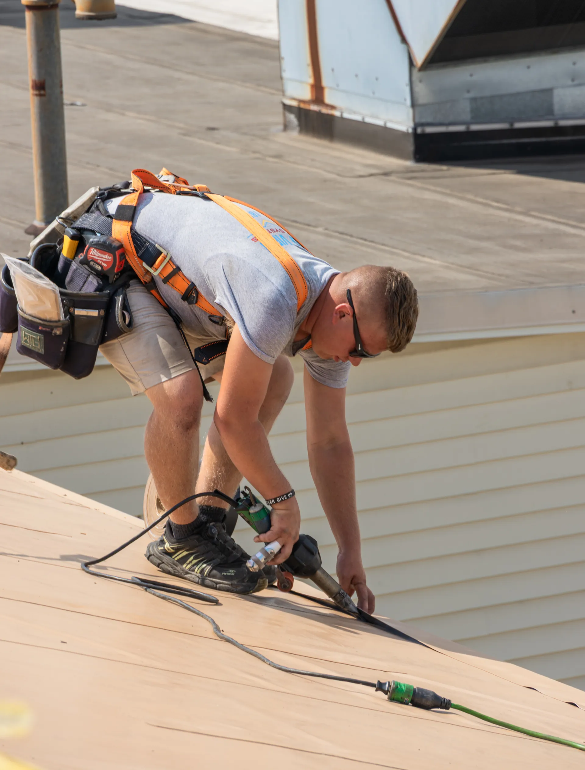 man in grey shirt doing maintenance work on roof