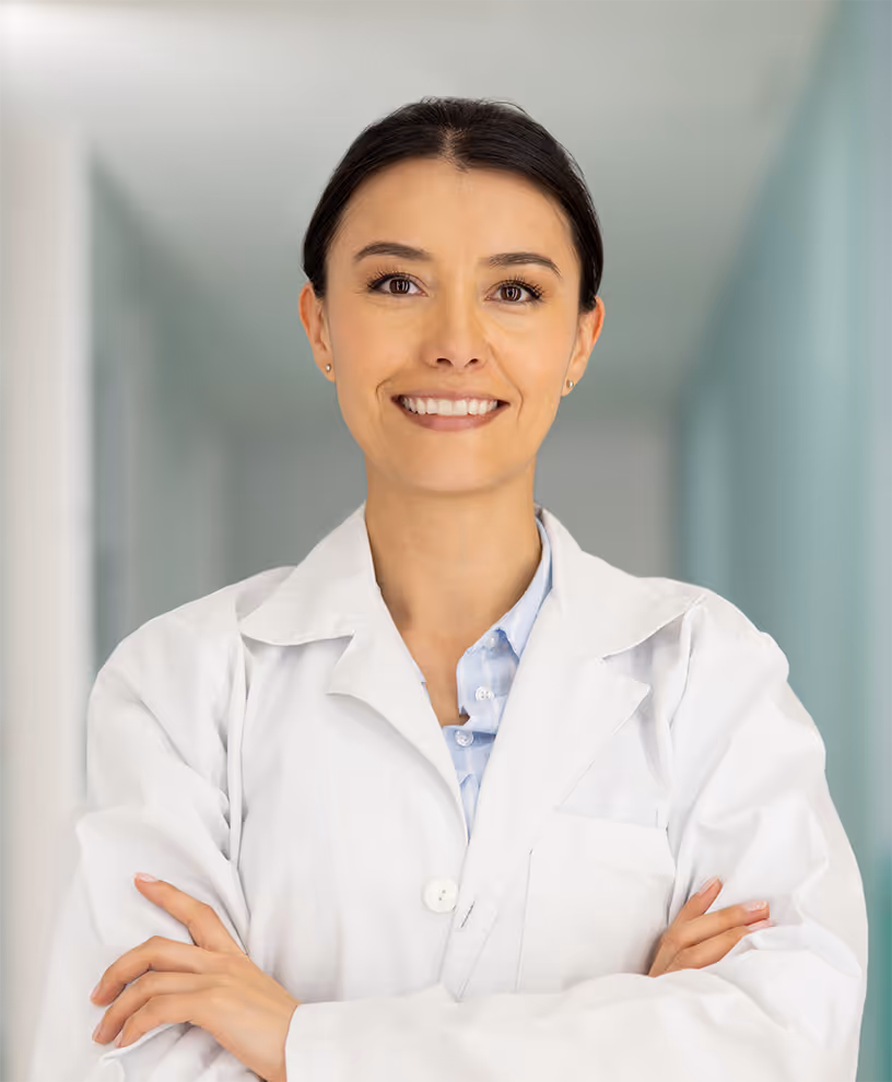 Female aesthetic surgeon in white lab coat with arms crossed, symbolizing precision and natural results