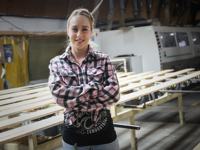 Employée devant machine 
à jointage de bois
