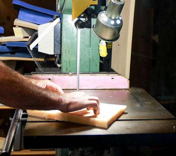 Personne qui coupe un morceau de mousse à coussin