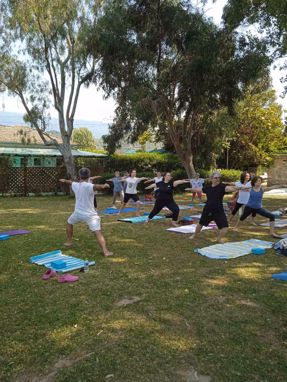 Πρωινή τάξη yoga σε παραλία, Virabhadrasana 2