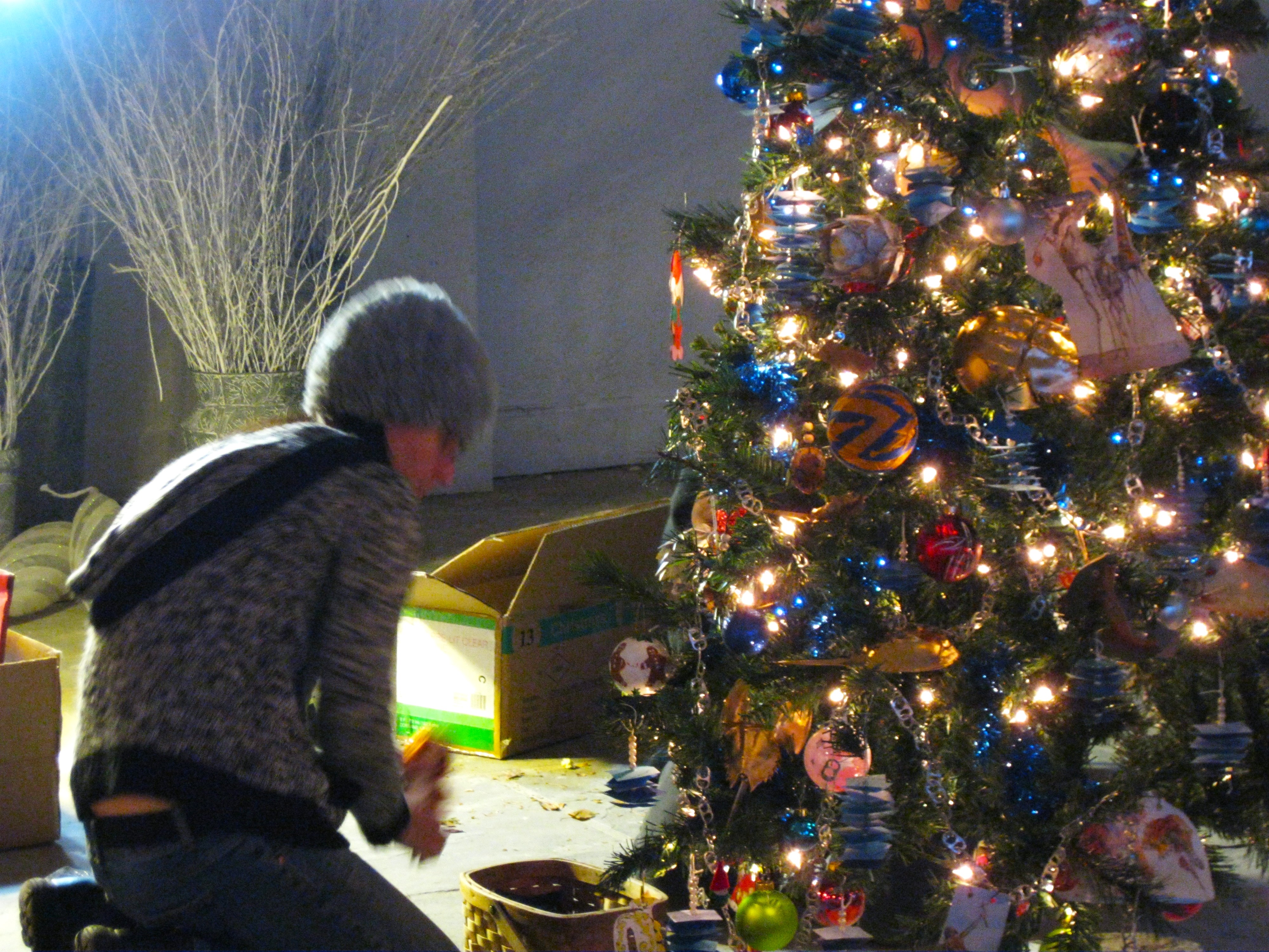 Person crouched by a tree