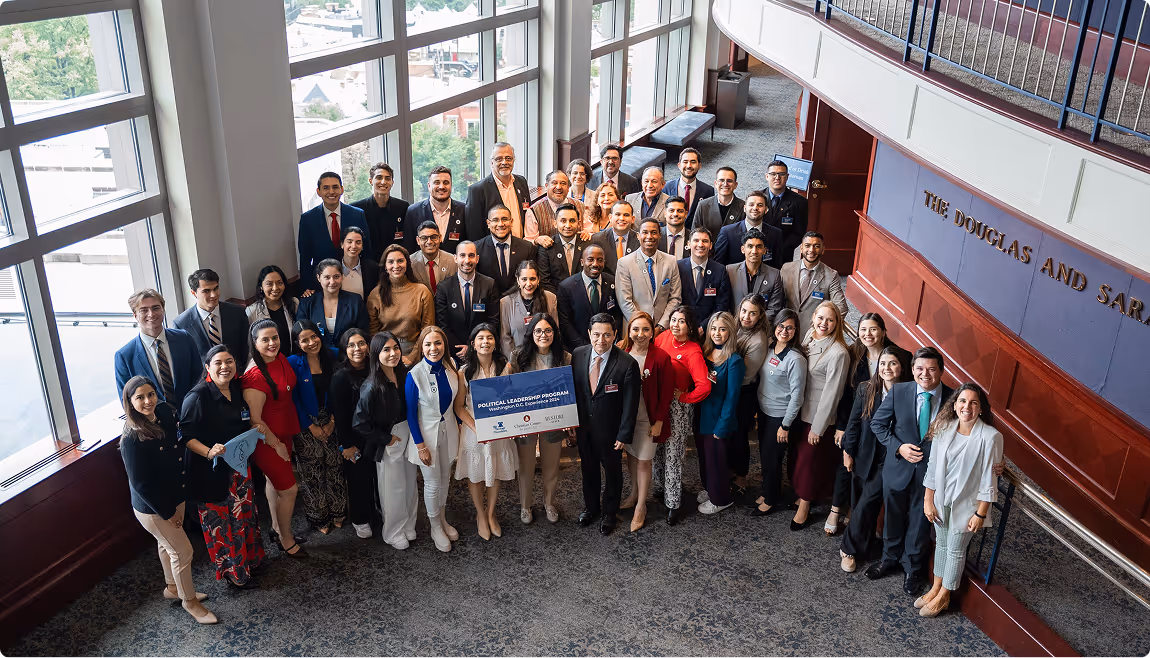A group of people standing in front of large windows.