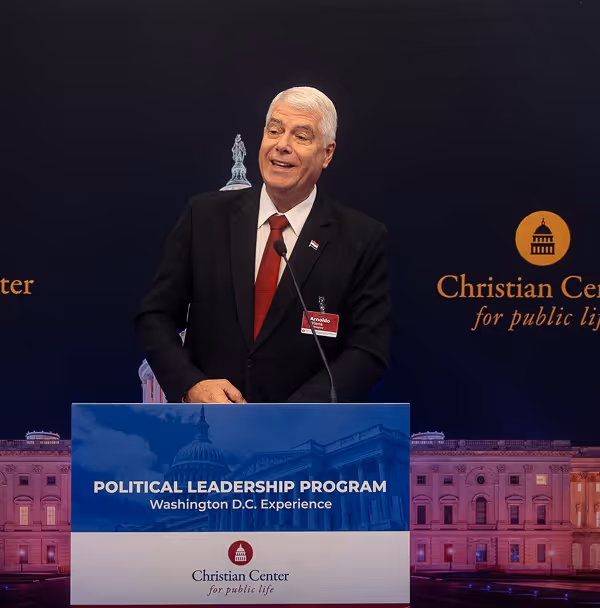 A man in a suit and tie standing at a podium.