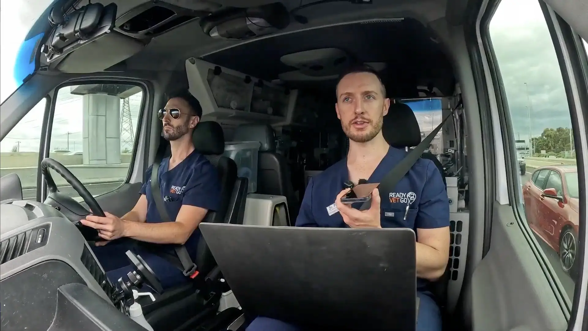 A scene from the Ready Vet Go TV Show, with two vet paramedics driving in a van.