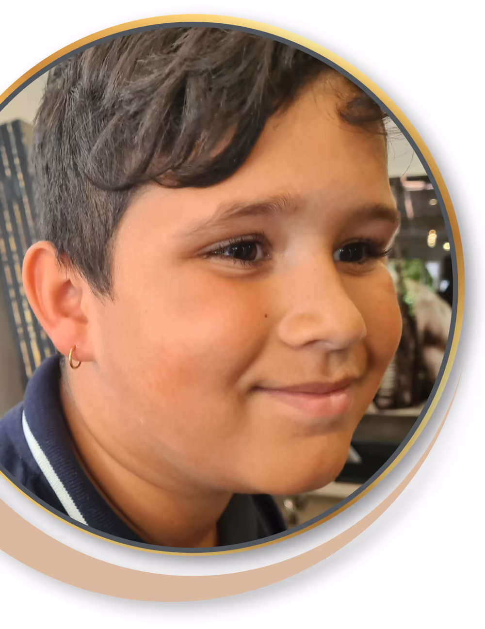 Nahaufnahme eines lächelnden Jungen mit kurzen dunklen Haaren und seinem ersten Ohrloch.