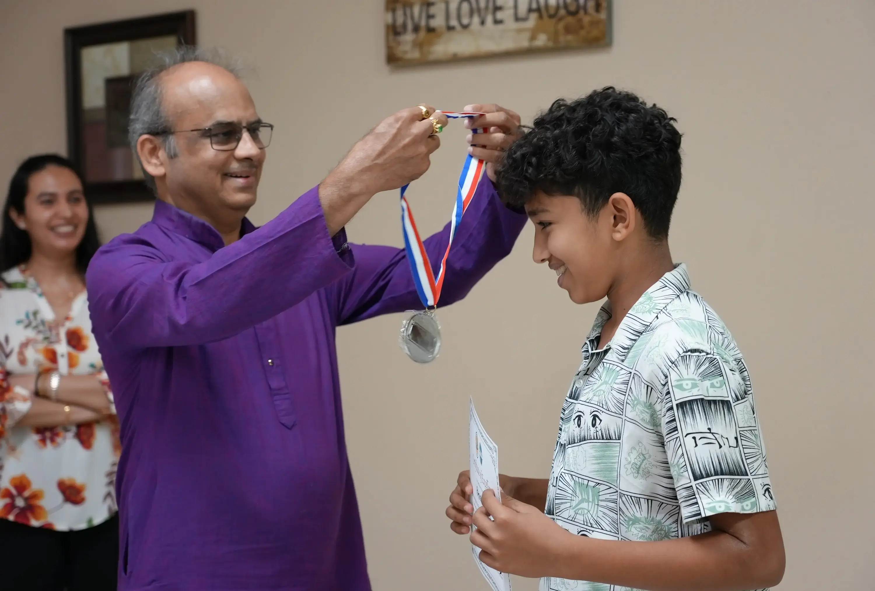A mentor recognizing a member's achievement with a medal