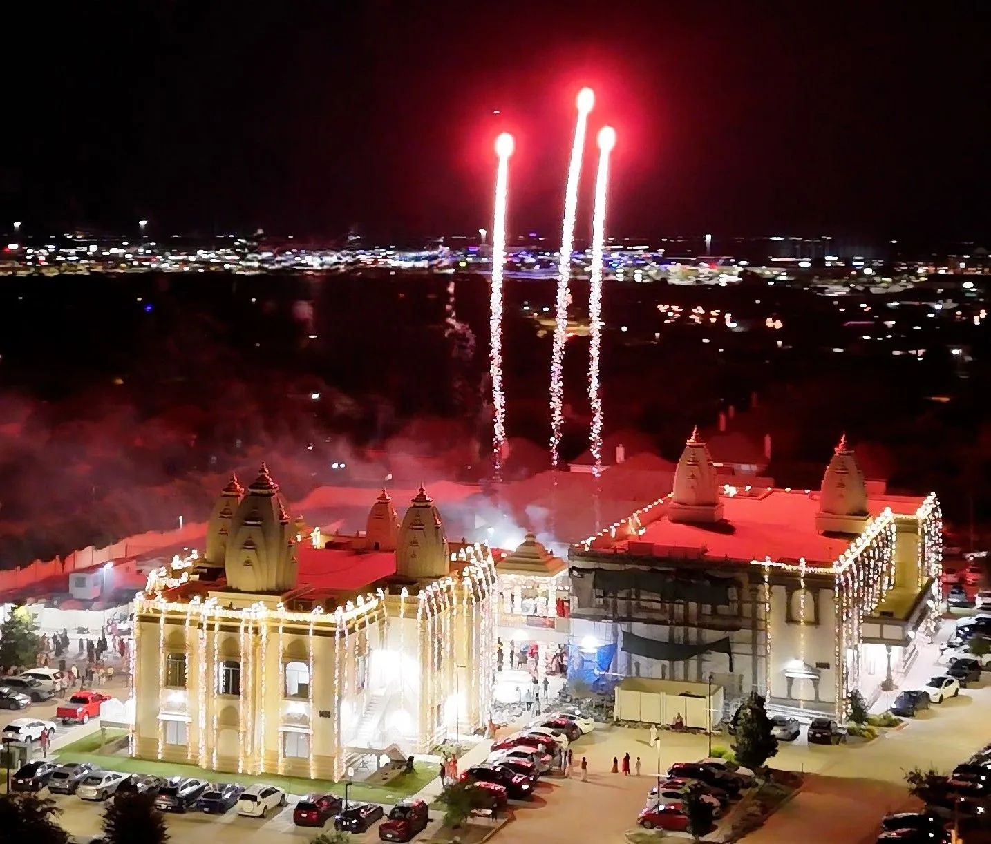 Fireworks bursting over the lit-up Radha Krishna Temple of Dallas at night