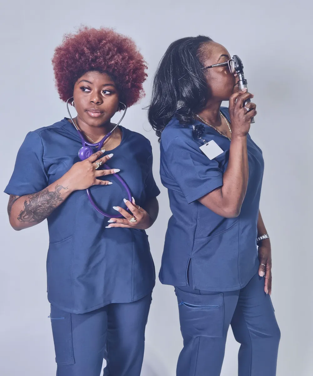 Two women wearing medical uniforms, standing and looking professional