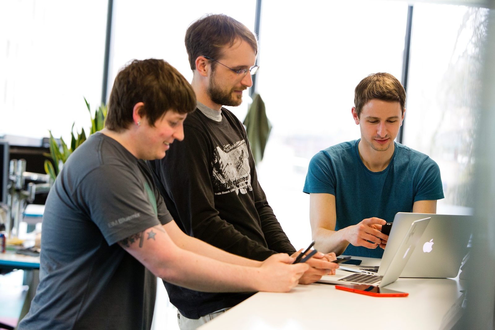 Collega's van Skyscanner werken samen aan een data-opdracht op een laptop