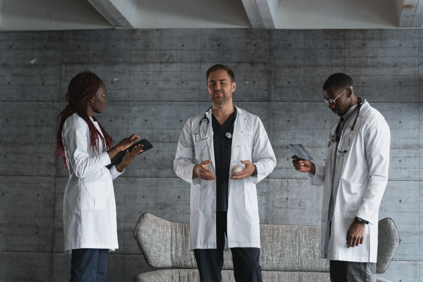 Three care professionals in conversation, one holding a tablet