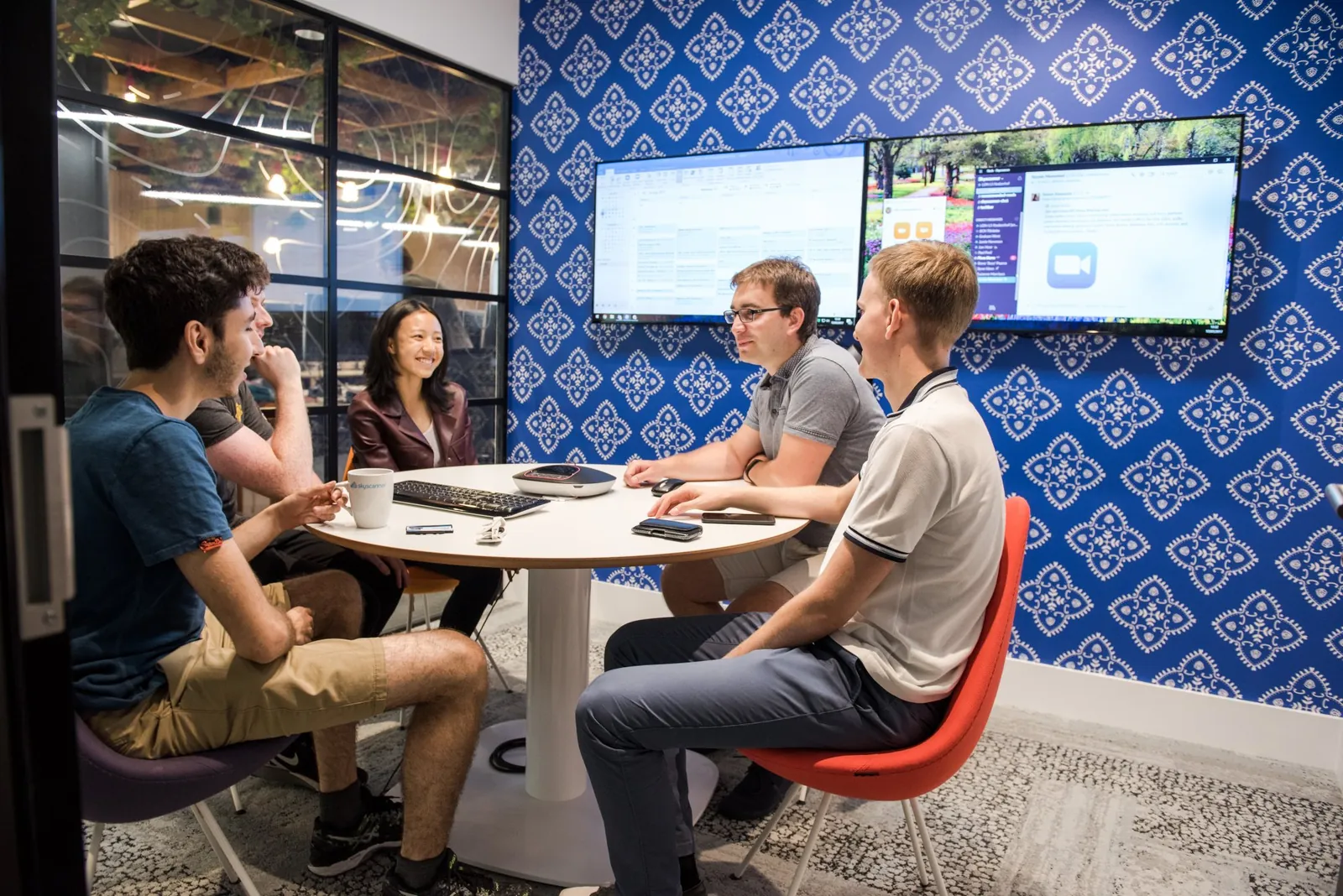 Four Skyscanner colleagues working together around a table in their office
