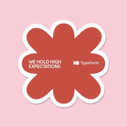 Typeform branded sticker with We Hold High Expectations text in red flower shape on pink background