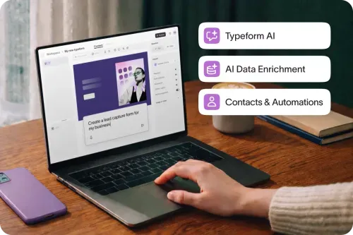 Laptop on desk showing Typeform builder with Typeform AI, Data Enrichment, and Contacts features