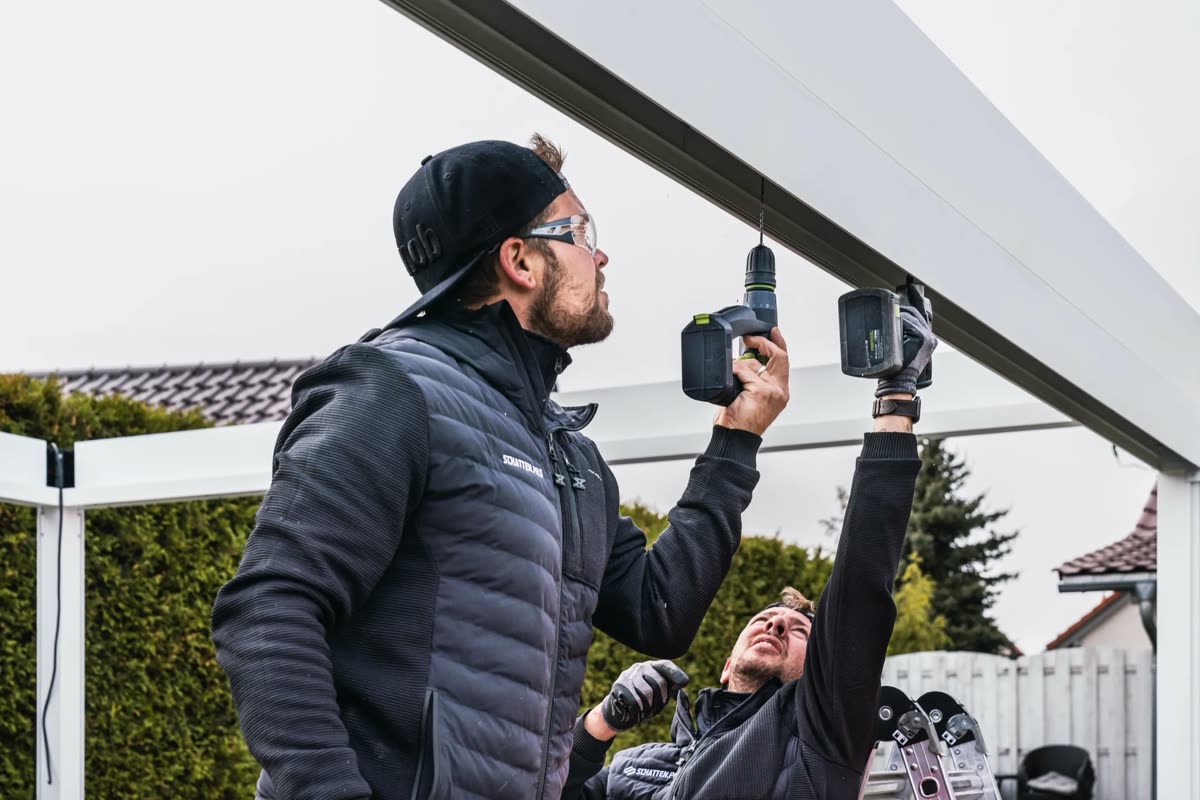 Monteur bei der Montage einer Terrassenüberdachung