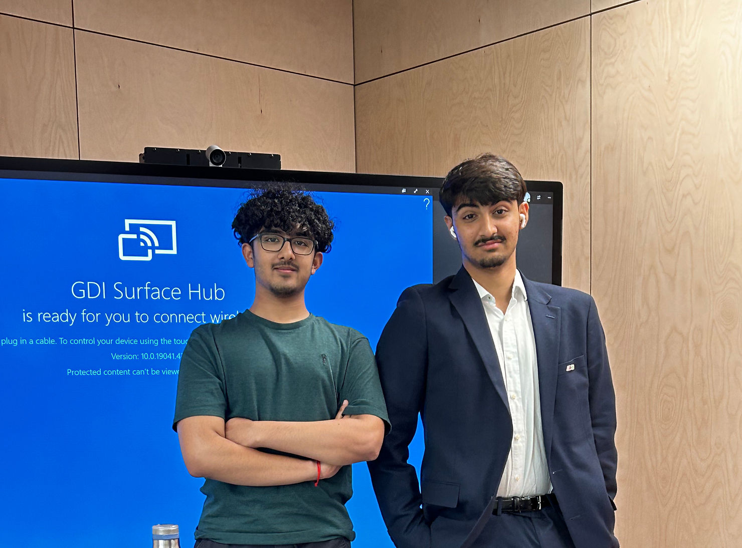Umer Fathany and Abhineet Rathore are 17 year old boys from South Asian origin. In this photo, Umer is wearing a blue blazer and trousers and Abhineet is wearing glasses and a green t-shirt