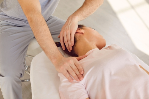 Trattamento osteopatico di collo e testa su una paziente sdraiata