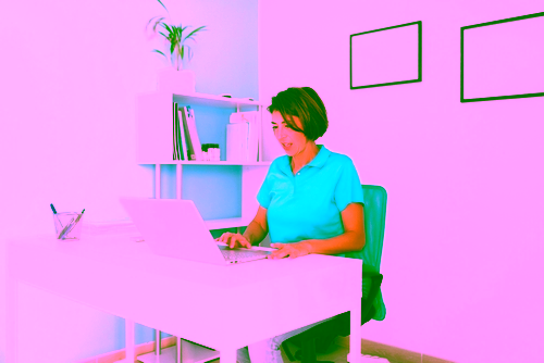 Therapeutin erfasst Rechnungen am Laptop im Büro ihrer Praxis