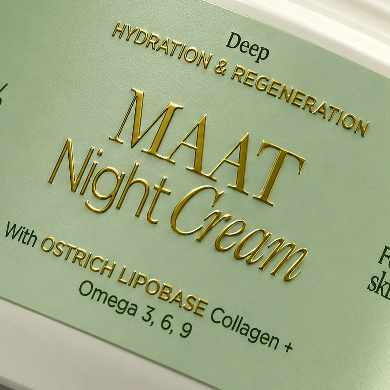Detaliu macro al etichetei MAAT Night Cream evidențiind emboss-ul auriu și textura premium a ambalajului.