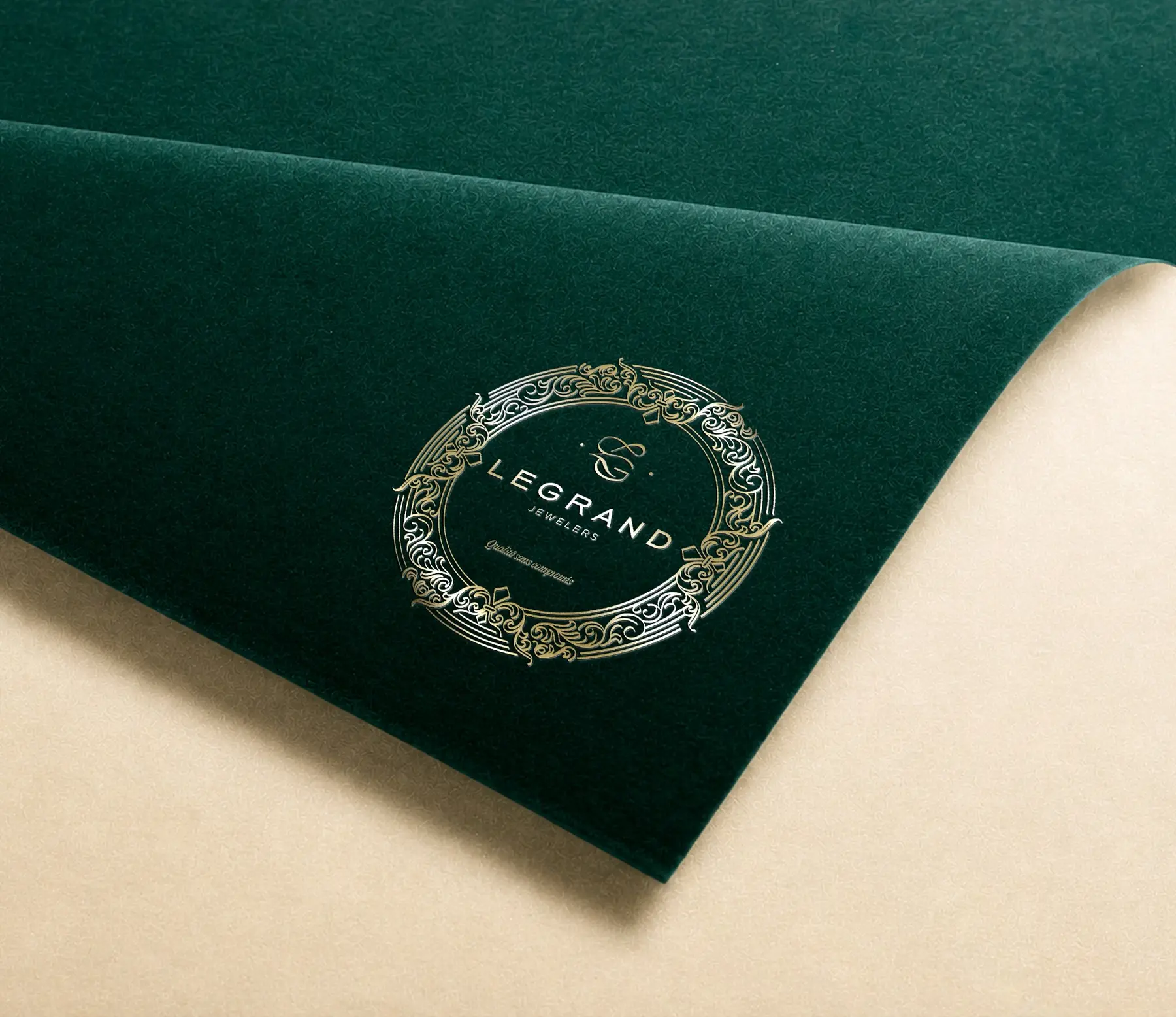 Detaliu al emblemei LeGrand Jewelers aplicate cu folie aurie pe catifea verde.