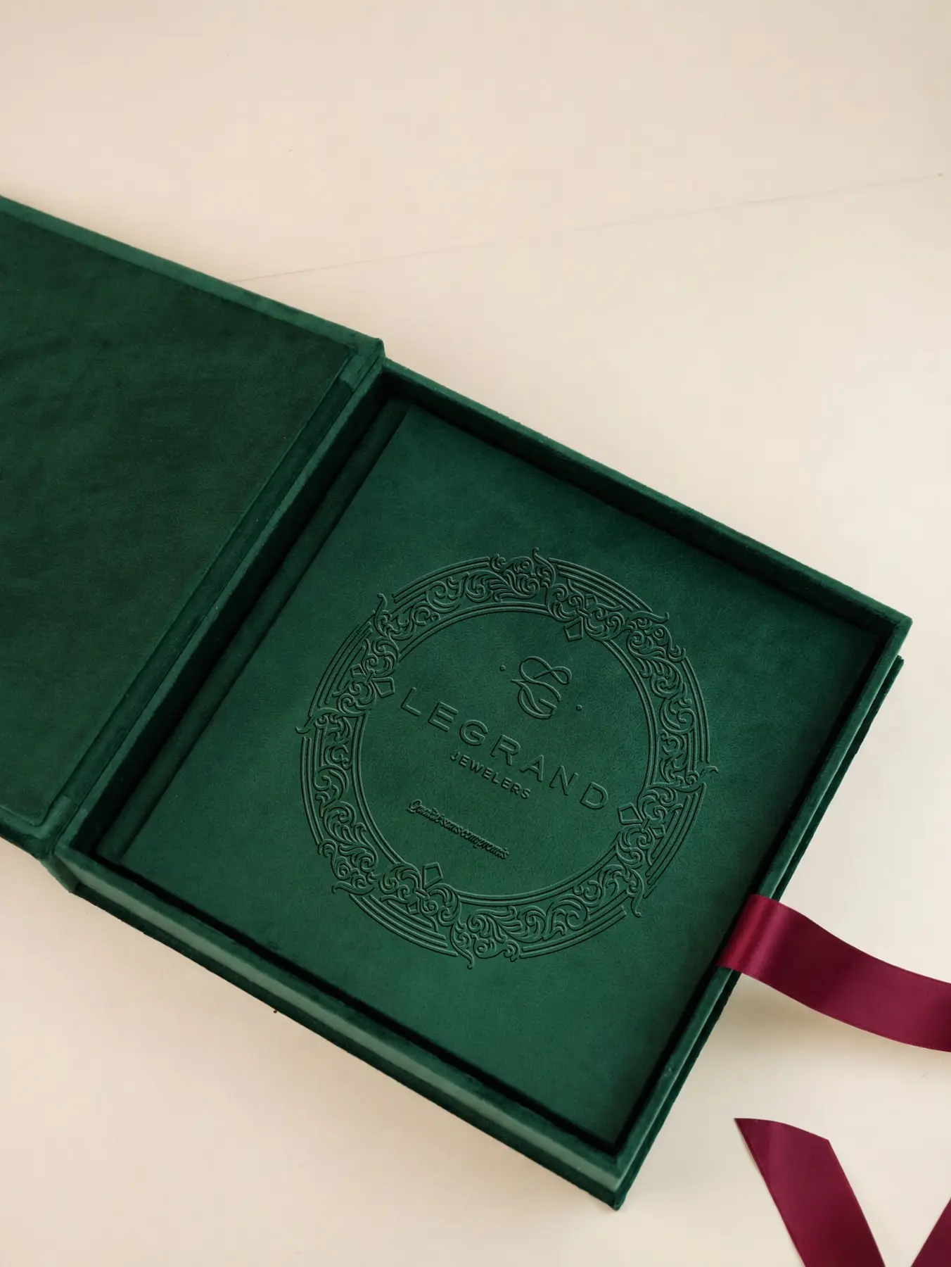 Manual de brand LeGrand Jewelers cu simbolul GL embosat pe copertă verde.