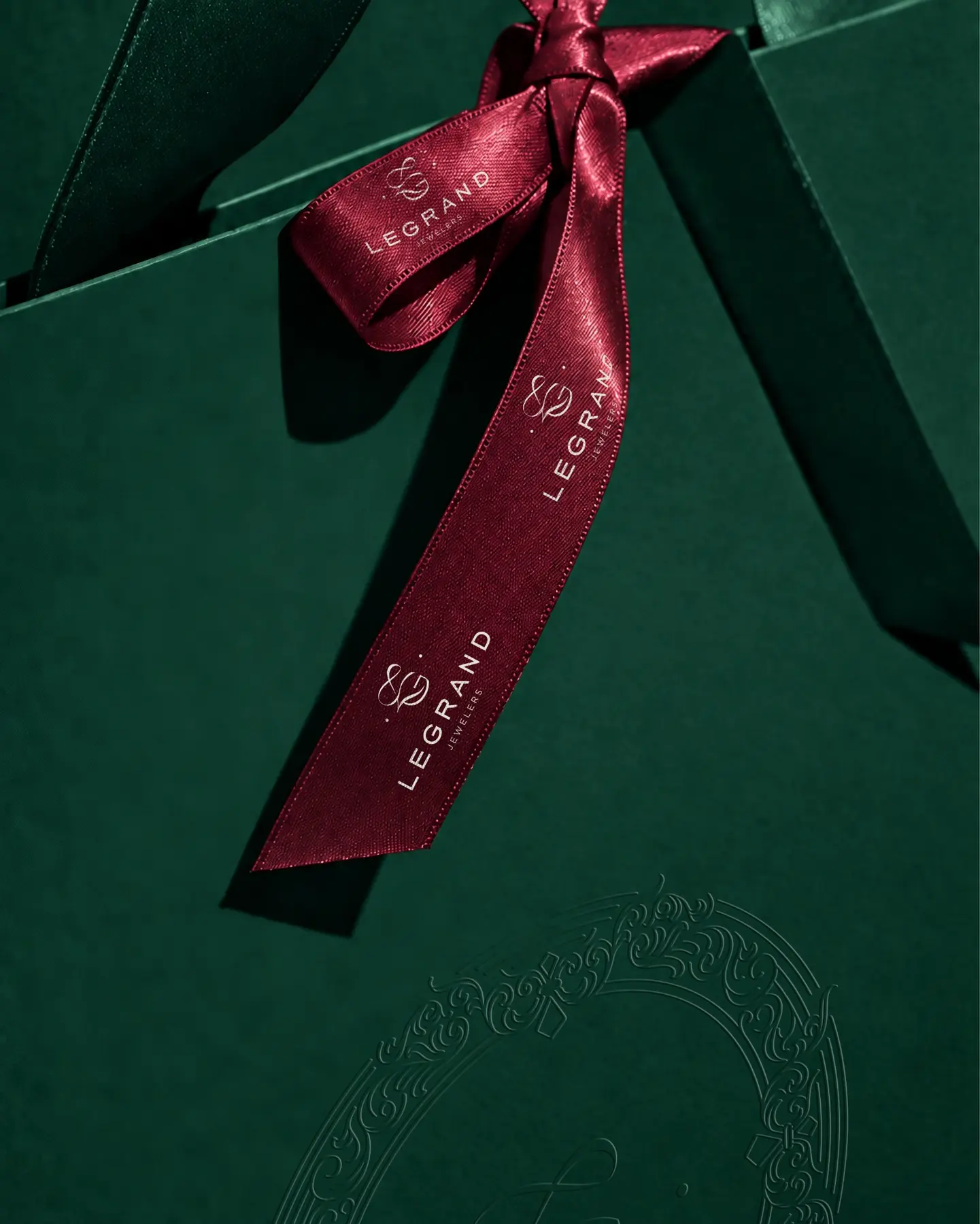 Ambalaj verde LeGrand Jewelers legat cu panglică burgundy personalizată.