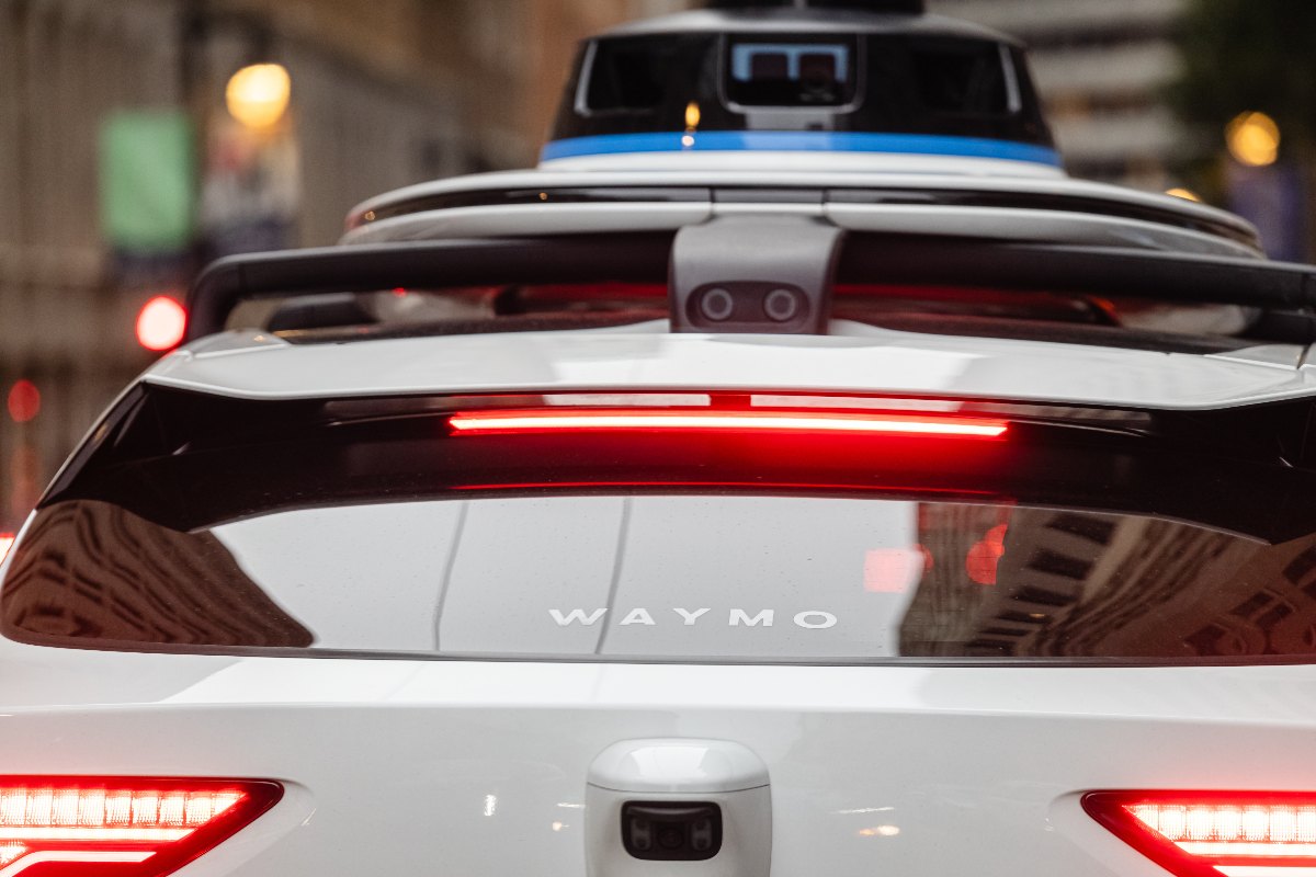 Rear view of a Waymo self-driving car with roof-mounted sensors