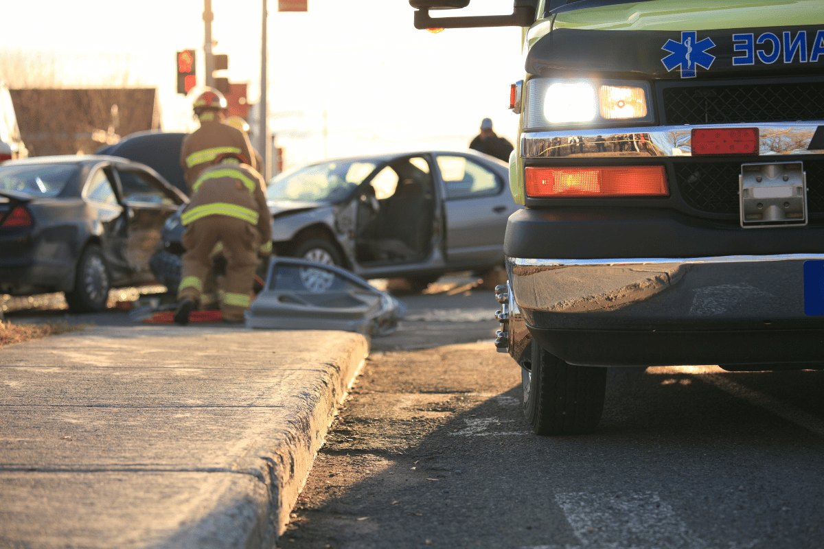 Firefighter and ambulance at the scene of a car crash
