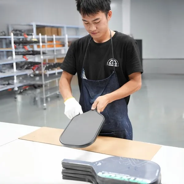 Worker checking a custom pickleball paddle during manufacturing