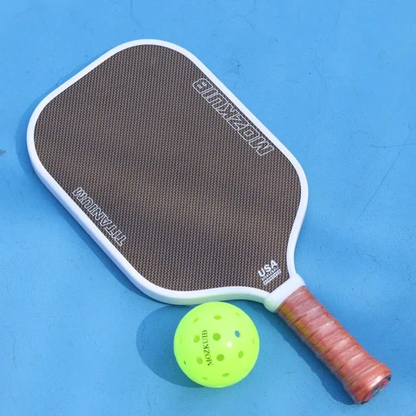 Mozkuib woven carbon pickleball paddle showing finished surface texture on a court
