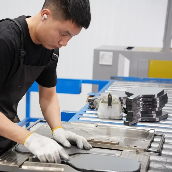 Carbon fiber layers being aligned during hot-pressed pickleball paddle production at Mozkuib